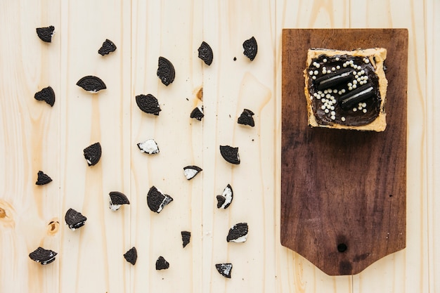 Gratis foto opgeheven mening van gebakje dichtbij koekjesstukken op houten achtergrond