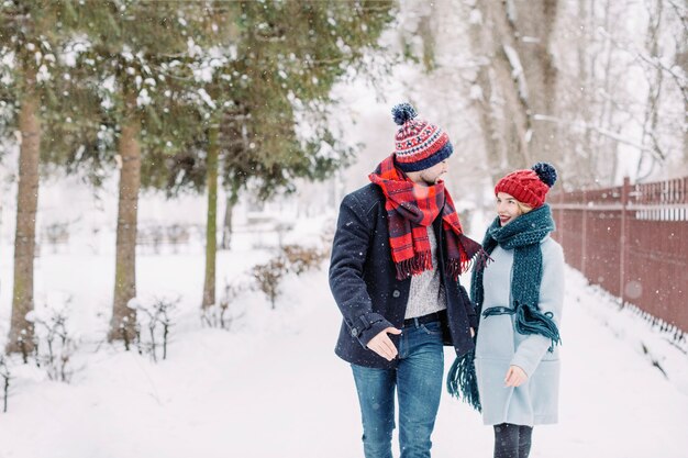 Opgewekt paar in liefde die in sneeuwval loopt