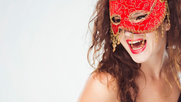 Opgewekte vrouw in rood masker