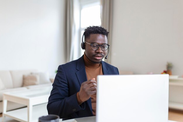 Opgewonden Afro-Amerikaanse man met koptelefoon die goed nieuws leest in e-mail en nieuwe baanpromotie krijgt met behulp van laptop die naar het scherm kijkt en schreeuwt van vreugde met ja gebaar vieren