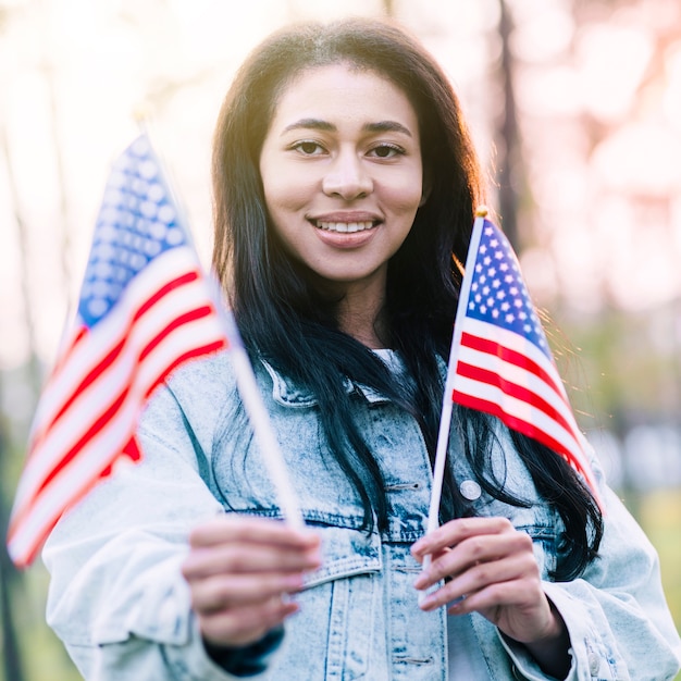 Opgewonden etnische vrouw met souvenir Amerikaanse vlaggen