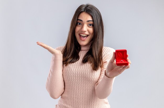 Opgewonden jong meisje op Valentijnsdag bedrijf trouwring verspreiden hand geïsoleerd op witte achtergrond