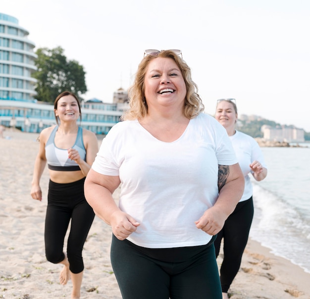 Gratis foto opgewonden jonge vrienden die op het strand lopen