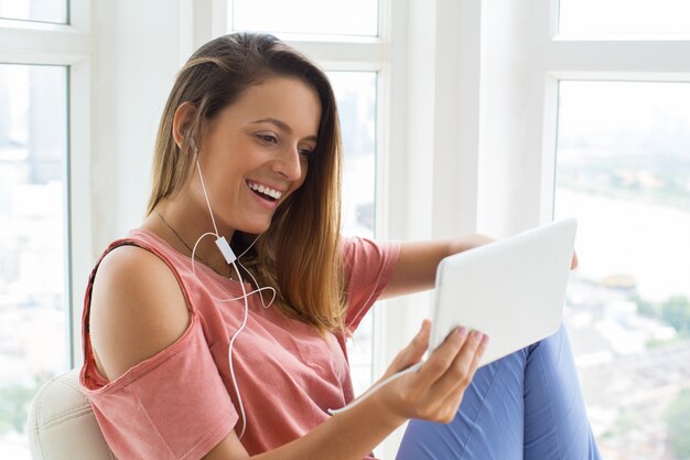 Opgewonden jonge vrouw kijken naar film op tablet