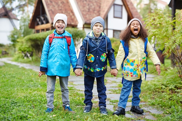 Opgewonden kleine kinderen gaan naar school