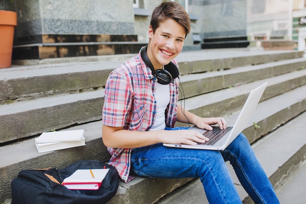 Gratis foto opgewonden man met gadgets op trappen