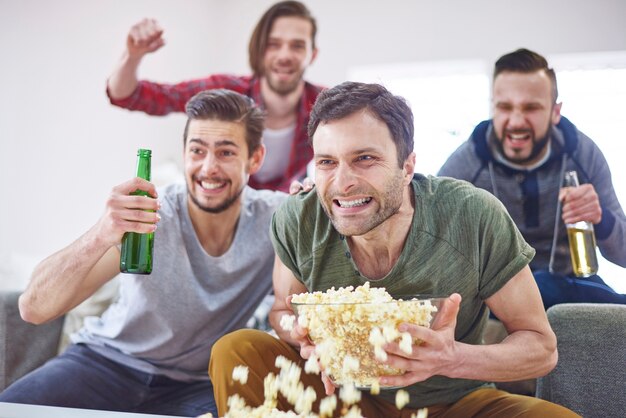 Opgewonden mannen kijken naar wedstrijd op tv