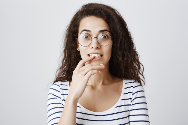 Opgewonden meisje kijkt met verleiding, bijtende vinger geïntrigeerd