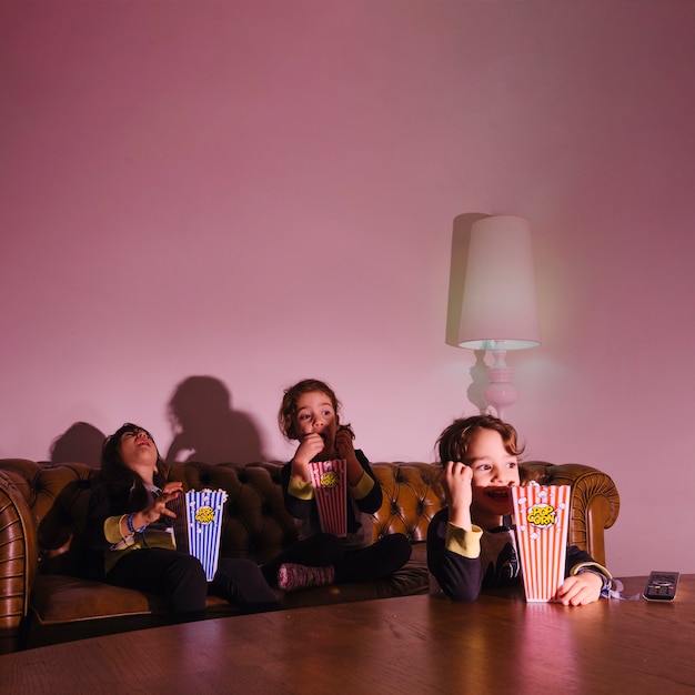 Gratis foto opgewonden meisjes die tv kijken in het donker