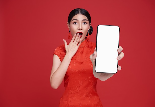Opgewonden mooie Chinese Aziatische vrouw met een smartphone mockup van een leeg scherm