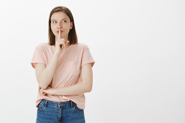 Opgewonden schattige vrouw heeft een geheim, shhh-gebaar, bereid verrassing voor, zwijgzaam, vraag zwijg