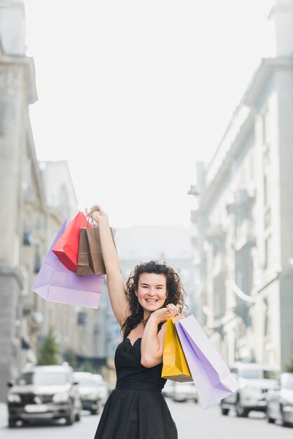 Opgewonden shopaholic vrouw met kleurrijke boodschappentassen