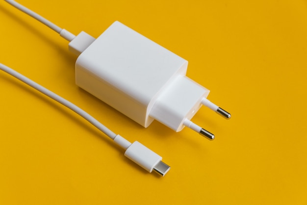 Oplader en USB-kabel type C op oranje achtergrond