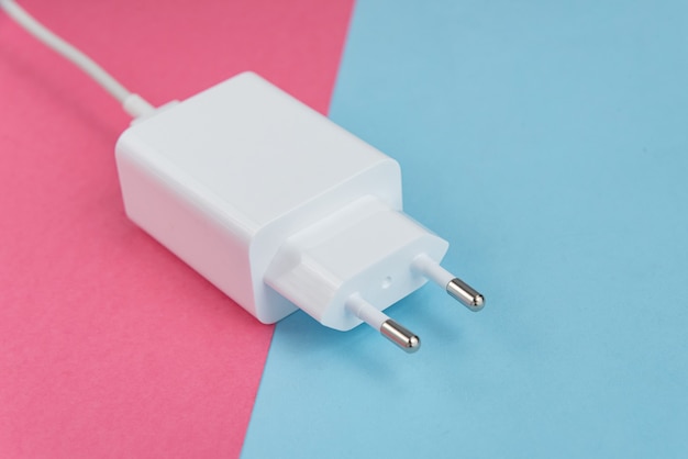 Oplader en usb-kabel type c over roze en blauwe achtergrond