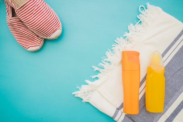 Oppervlak met handdoek, lotions en zomer schoenen