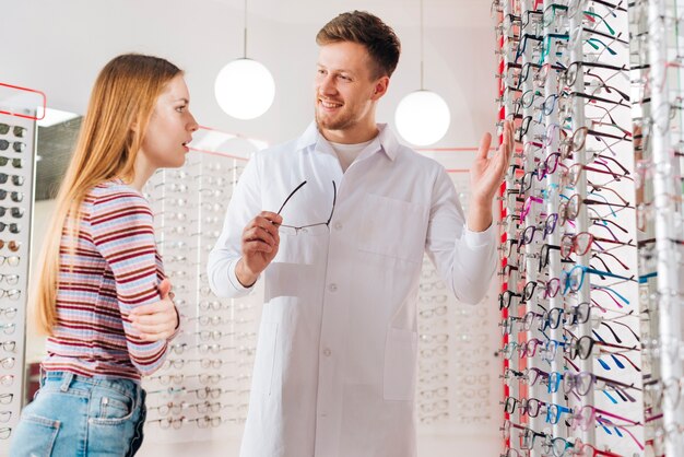 Optometrist die vrouw adviseren die glazen kiezen