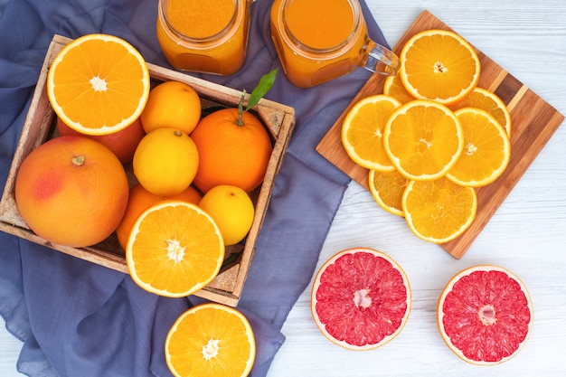 Oranje fruit concept jus d'orange grapefruit oranje fruit op houten snijplank op violette doek