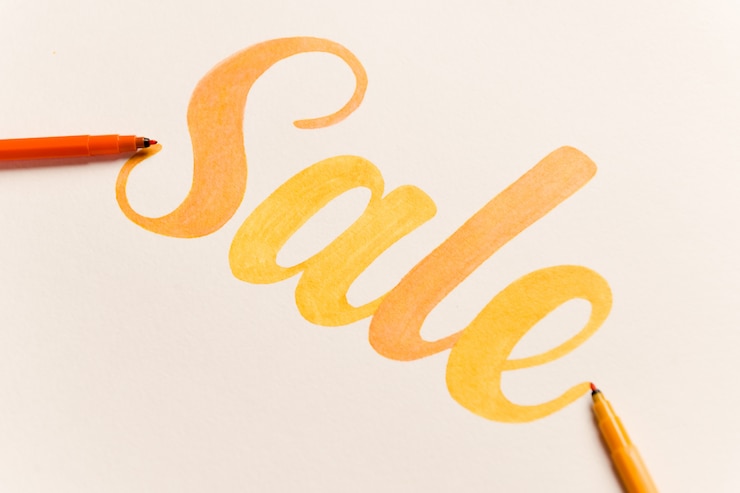 Gratis Foto oranje geschilderde belettering verkoop op witte achtergrond
