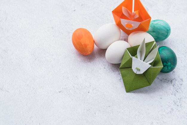 Origami van groene en oranje konijnen en een set van paaseieren