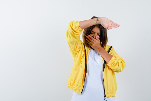 Ortrait van vrouw die hand op mond houdt, stopgebaar in t-shirt, jasje toont en verontrust vooraanzicht kijkt