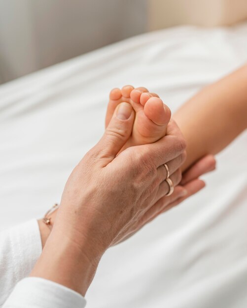 Osteopaat die de voeten van een babymeisje behandelt