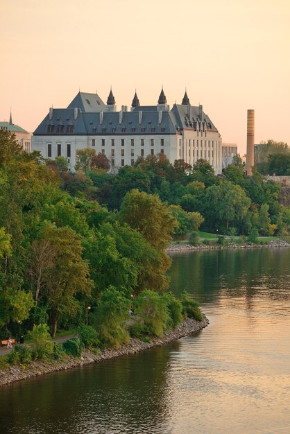 Ottawa zonsondergang over rivier met historische architectuur.