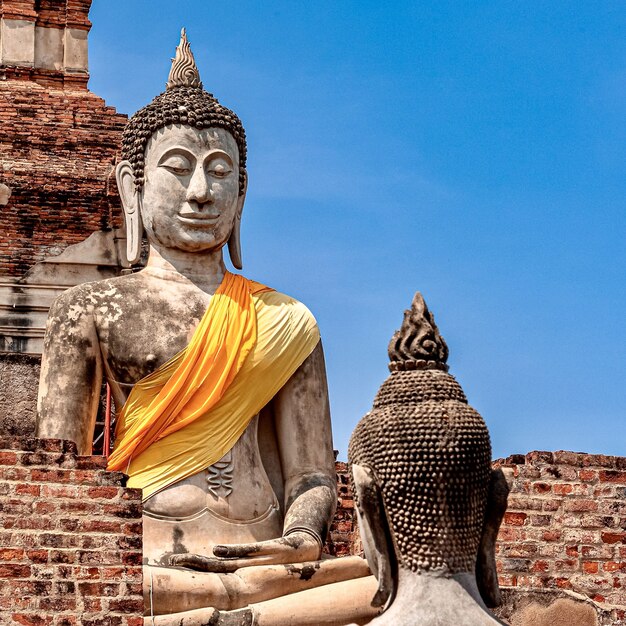 Oud Boeddhabeeld bedekt met gele stof
