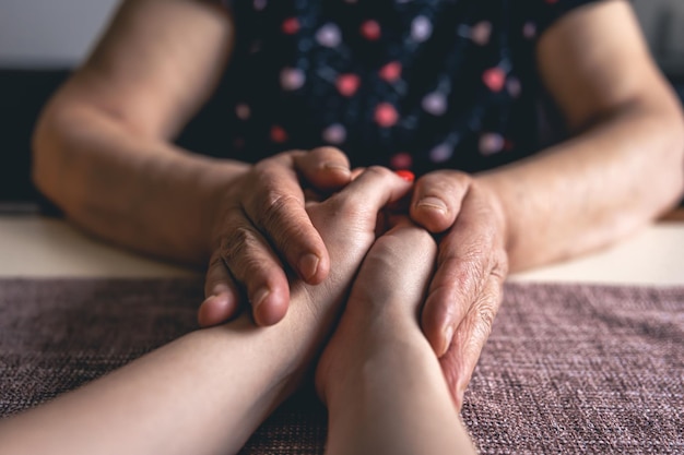 Oude en jonge man hand in hand close-up