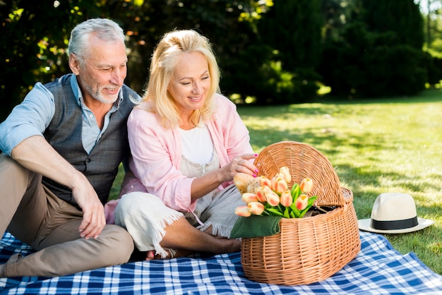 Gratis foto oude man en vrouw die de picknickmand bekijken