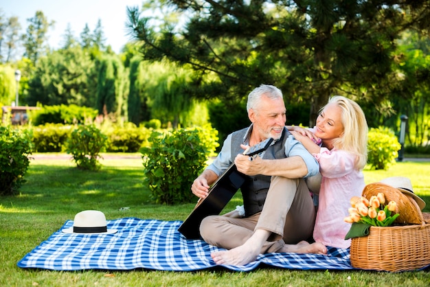 Oude man en vrouw op een deken op de picknick