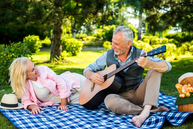 Oude man gitaar spelen voor zijn vrouw