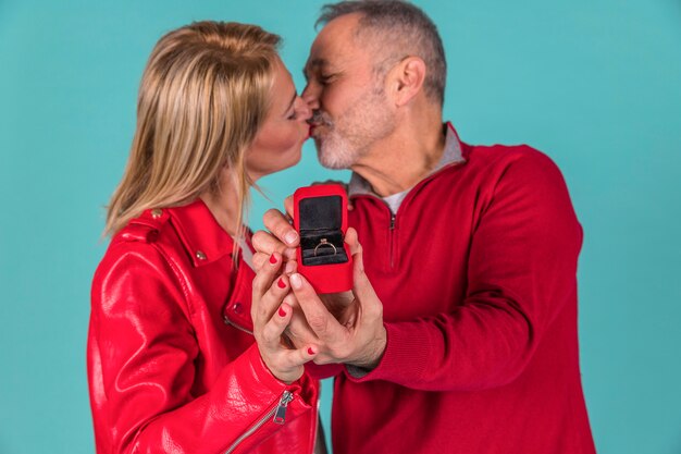 Oude man kussen met vrouw en sieraden doos tonen