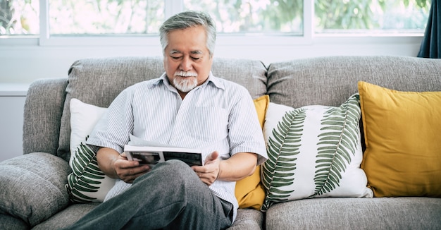 Oude man leest in de woonkamer