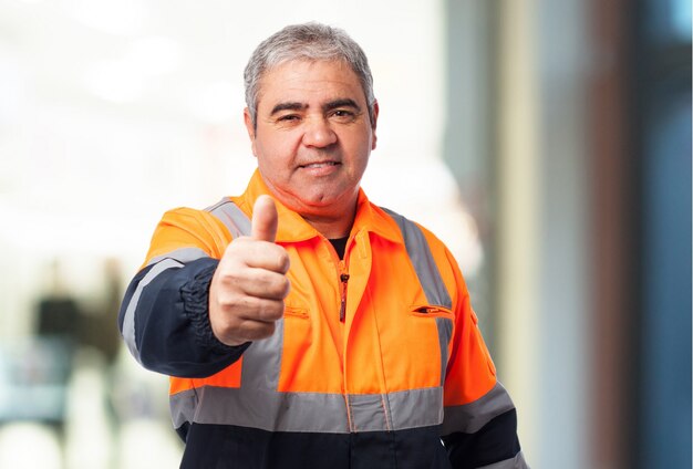 Oude man met een reflecterende pak met duim omhoog