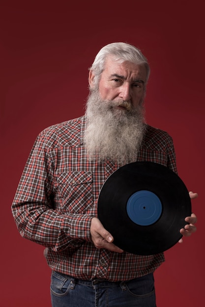 Gratis foto oude man met een vinyl schijf