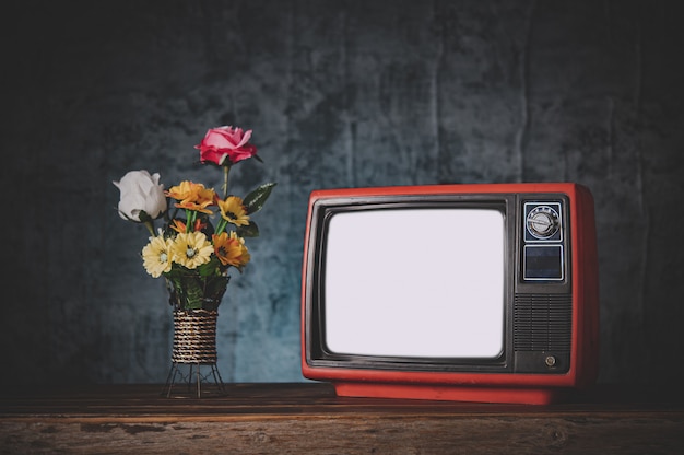 Gratis foto oude retro-tv het is nog steeds leven met bloemenvazen