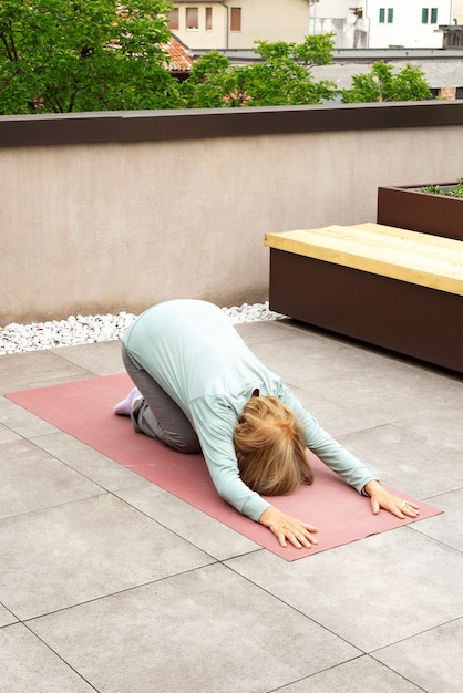 Oude vrouw die fitnessoefeningen doet