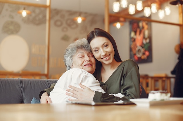 Oude vrouw in een café met jonge kleindochter