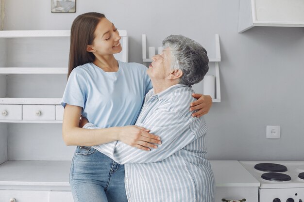 Oude vrouw in een keuken met jonge kleindochter