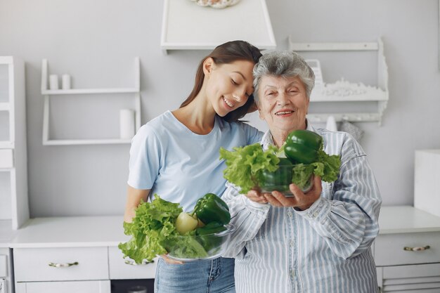 Oude vrouw in een keuken met jonge kleindochter