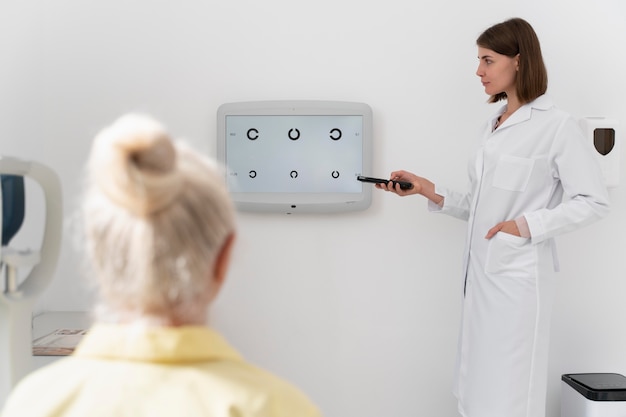 Gratis foto oude vrouw met oogcontrole in een oogheelkundige kliniek