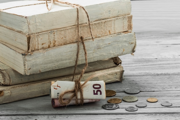 oude witte boeken met geld en munten op houten achtergrond