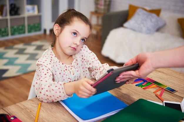 Ouder die de tablet van het kind weghaalt