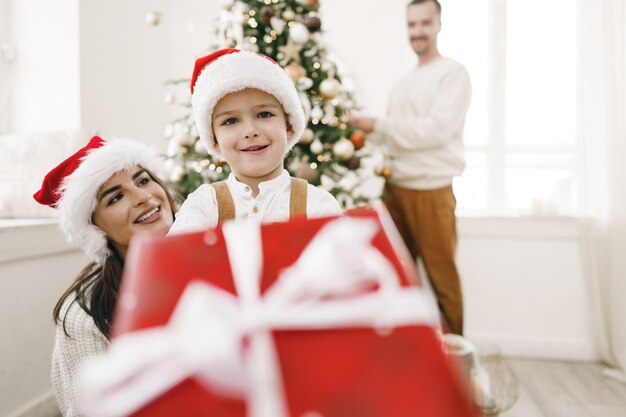 Ouder en hun zoontje hebben plezier en spelen samen binnenshuis met Kerstmis