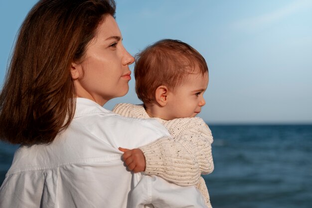 Ouder met baby op het strand bij zonsondergang