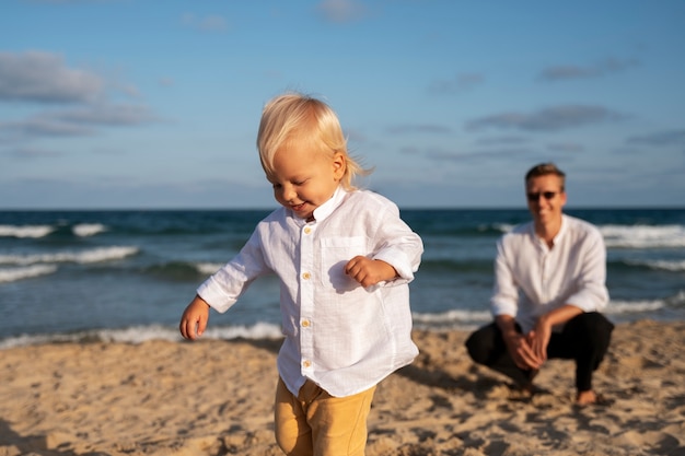 Gratis foto ouder met baby op het strand bij zonsondergang