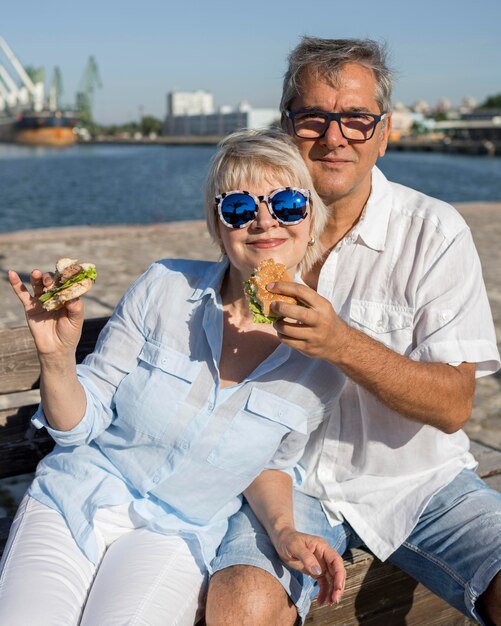 Ouder stel dat samen buiten van een hamburger geniet