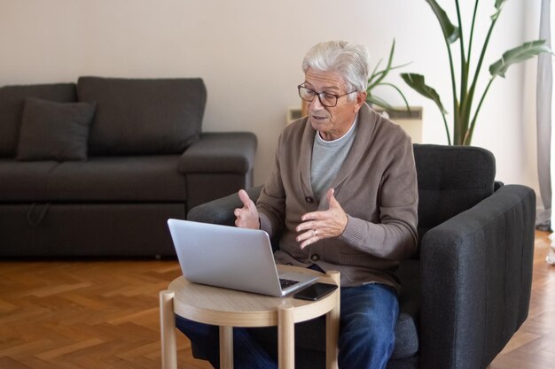 Oudere man die online met baas communiceert