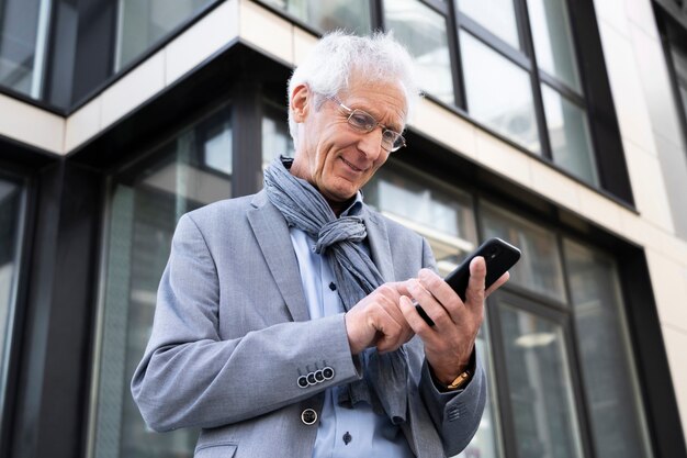 Oudere man in de stad met smartphone