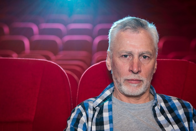 Oudere man kijkt naar film in de bioscoop
